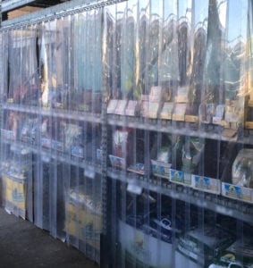 Plastic strip curtain protecting racks of seeds from birds. 
